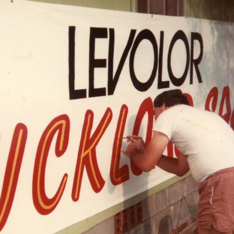 Image of founder hand painting a sign